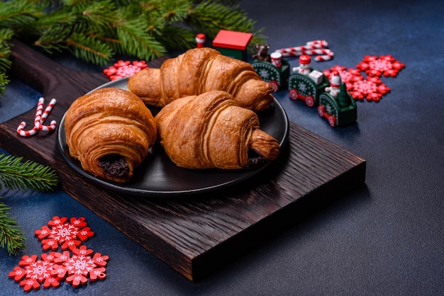 Krokante chocoladecroissant met kerstversiering op houten snijplank