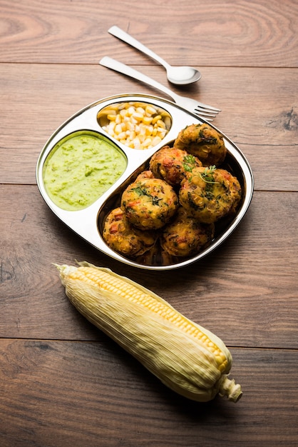 Krokante Corn Tikki, pakora of pakoda of pattice ook wel bekend als kotelet. geserveerd met groene chutney. Selectieve focus