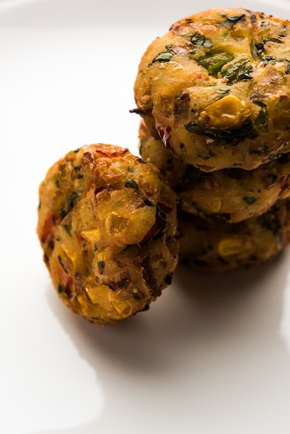 Krokante Corn Tikki, pakora of pakoda of pattice ook wel bekend als kotelet. geserveerd met groene chutney. Selectieve focus
