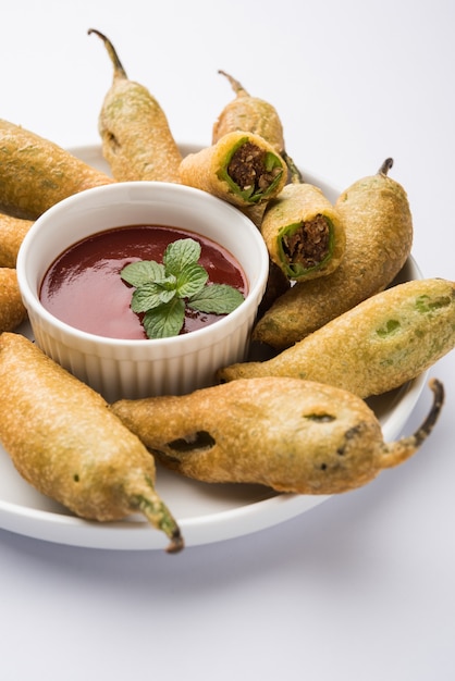 Krokante Groene Chilli Pakora of Mirchi Bajji, geserveerd met tomatenketchup. Het is een populaire theetijdsnack uit India, vooral in Monsoon. Selectieve focus