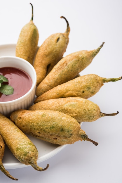 Krokante Groene Chilli Pakora of Mirchi Bajji, geserveerd met tomatenketchup. Het is een populaire theetijdsnack uit India, vooral in Monsoon. Selectieve focus