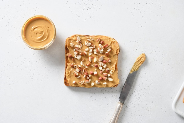 Krokante toast met pindapasta voor gezond ontbijt op wit Uitzicht van bovenaf