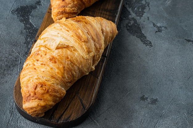 Krokante verse croissants set, op grijze stenen achtergrond, met kopie ruimte voor tekst