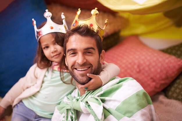 Kroon aankleden en papa met prinses plezier in een slaapkamerfort met gekostumeerd meisje en papa samen Speel kasteelgeluk en glimlach met vader en kind in een huis opgewonden en blij over een spel