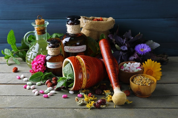 Kruiden bessen bloemen en pillen op een houten tafel achtergrond kleur