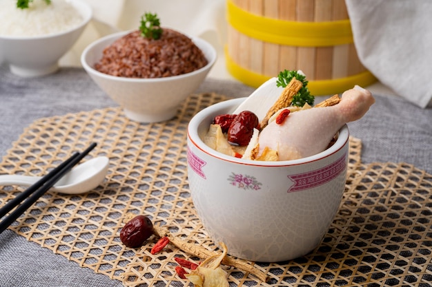 KRUIDEN KIPPENSOEP met lepel geserveerd in hete pot geïsoleerd op tafelblad van singapore voedsel