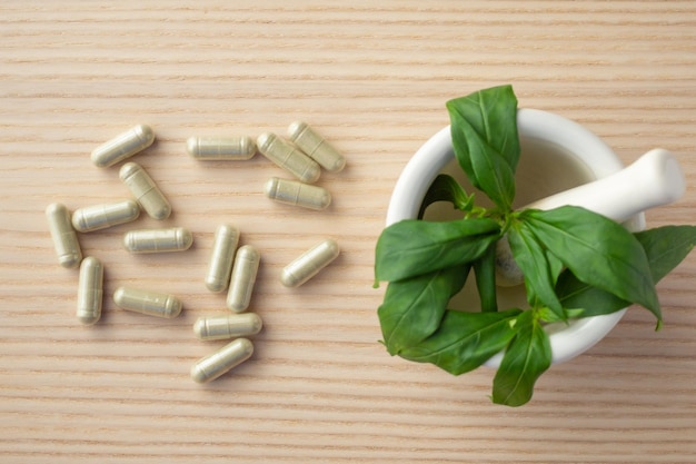 Foto kruidengeneesmiddelencapsules met andrographis paniculata-blad op houten tafel