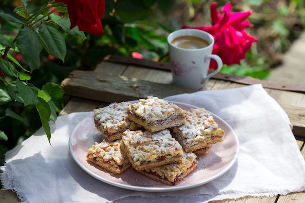 Kruidentaart gevuld met rozenjam, geserveerd met koffie. Rustieke stijl.