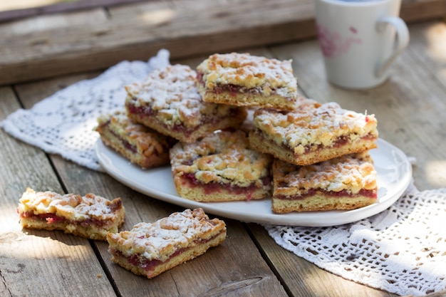 Kruidentaart gevuld met rozenjam, geserveerd met koffie. Rustieke stijl.