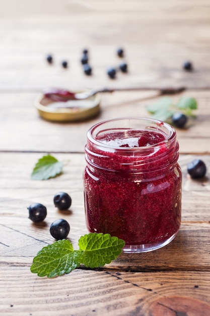 Kruik eigengemaakte bosbessenjam op een houten oppervlakte