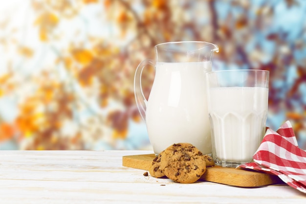 Kruik en een glas melk op een houten tafel