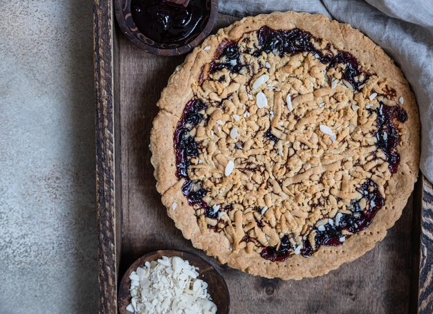 Kruimeltaart met jam in houten dienblad Zelfgemaakte streusel jamtaart Bovenaanzicht Selectieve aandacht