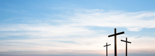 Kruis van Jezus Christus leeg over het dramatische panorama van de zonsopganghemel met wolken.