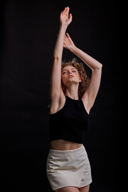 Krullend dunne jonge vrouw poseren in de fotostudio.