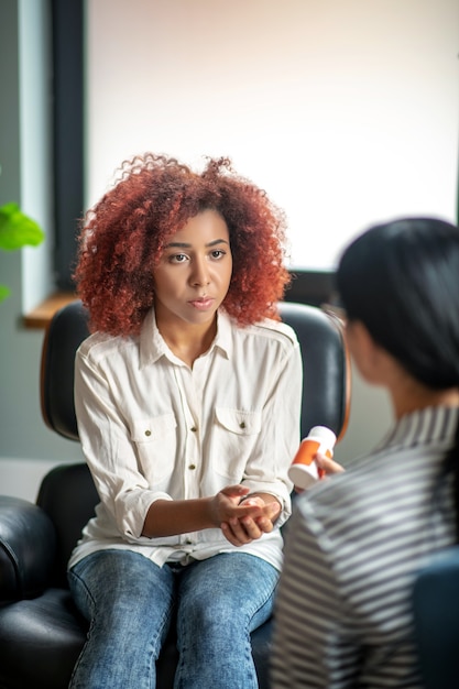 Foto krullend jongedame in gesprek met haar psychotherapeut