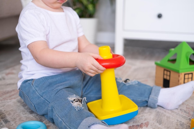 Krullend kind meisje spelen met piramide en constructor thuis vroege kinderen ontwikkeling