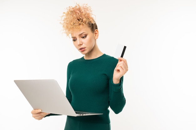 Krullend meisje dat laptop in haar handen op wit houdt