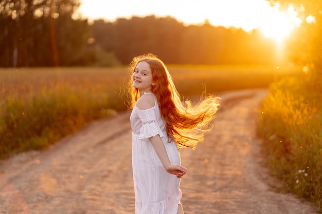 Foto krullend meisje genietend van de zonsondergang in het veld