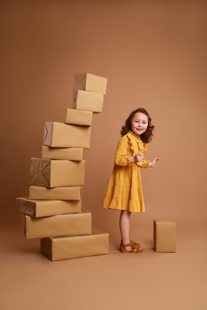 Krullend meisje met grote stapel cadeaus voor de vakantie