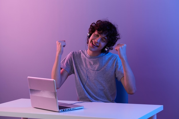 Krullende man in koptelefoon voor laptop entertainment geïsoleerde achtergrond