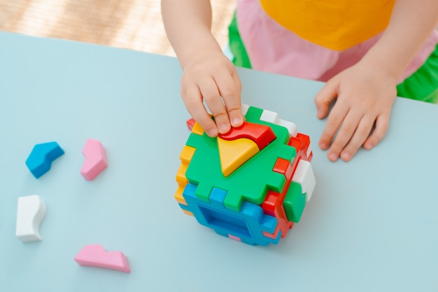 Kubus met ingevoegde geometrische vormen gekleurde plastic blokken