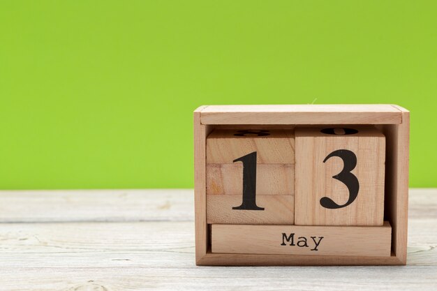 Foto kubuskalender voor 13 mei op hout met kopie ruimte