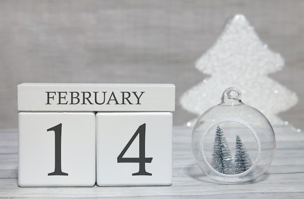 Kubusvormkalender voor 14 februari op houten oppervlak en lichte achtergrond