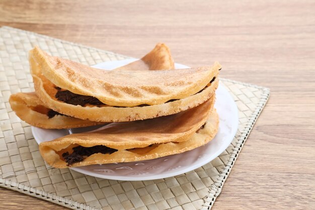Sepiring kue lekker crispy dengan topping keju parut dan meises cokelat