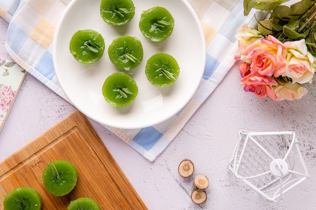 Photo kue lumpang pandan or kue ijo 

kue ijo is a traditional green cake and is small in size steamed and has a rubbery texture served with grated coconut its popular snack from indonesia