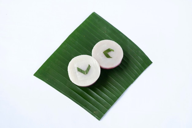 흰색 배경에 고립 된 바나나 잎에 Kue talam. 인도네시아 전통 케이크.