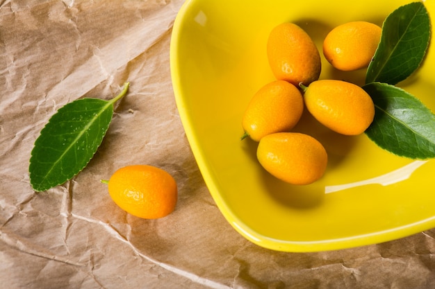 Kumquat on plate at wooden table