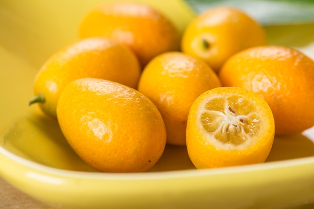 Kumquat on plate at wooden table