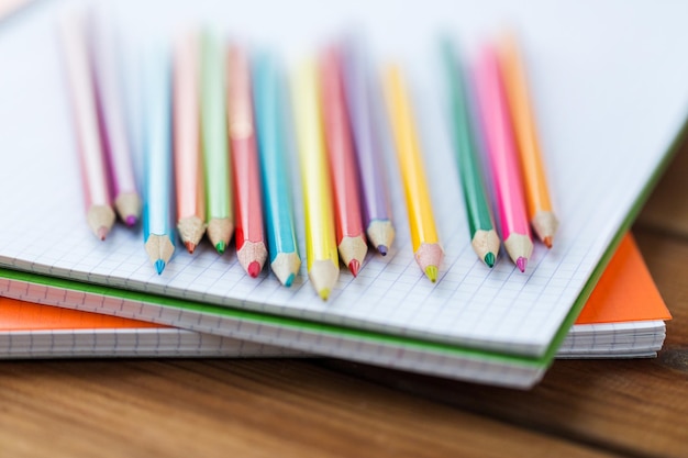 kunst, school, onderwijs, tekenen en objectconcept - close-up van kleurpotloden of kleurpotloden op notebookpapier