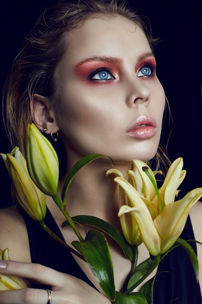 Kunst schoonheid meisje gezicht close-up met lelies in handen
