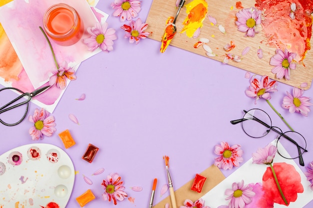 kunstbenodigdheden, paarse bloemen en glazen op violette tafel