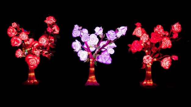 kunstbomen in rode en roze kleuren op een lichtfestival