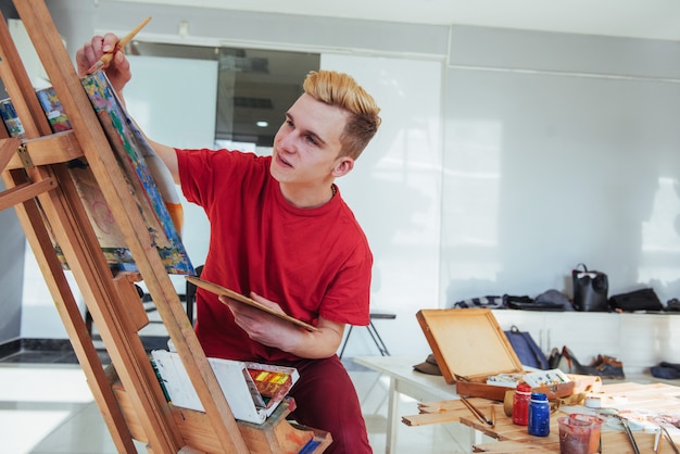 Foto kunstenaar die een foto in een studio schildert