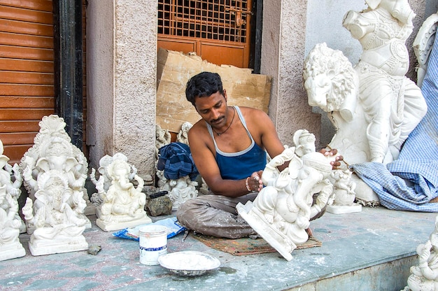 Kunstenaar geeft de laatste hand aan een idool van de hindoegod Lord Ganesha tijdens een artist39s-workshop voor Ganesha-festival