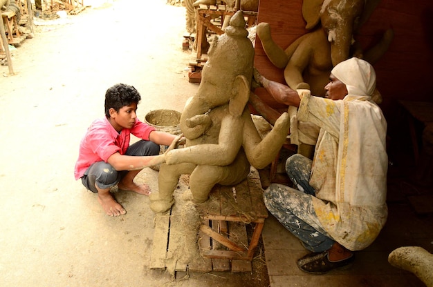 Kunstenaar geeft de laatste hand aan een idool van de hindoegod Lord Ganesha tijdens een artist39s-workshop voor Ganesha-festival