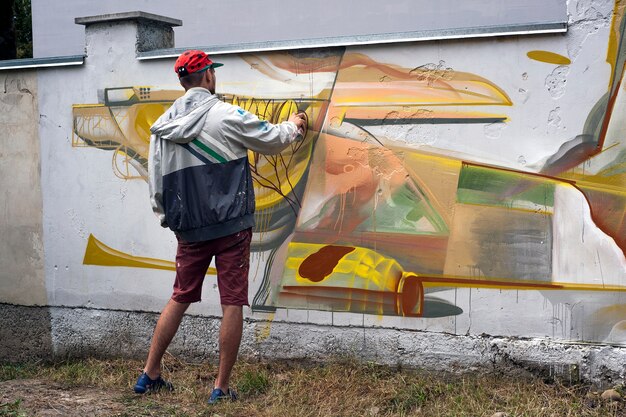 Kunstenaar schildert graffiti op een betonnen muur.