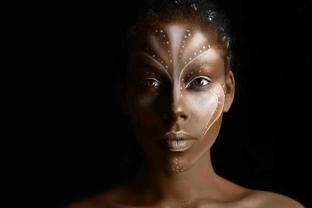 Kunstfoto van afrikaanse vrouw met tribale etnische schilderijen op haar gezicht