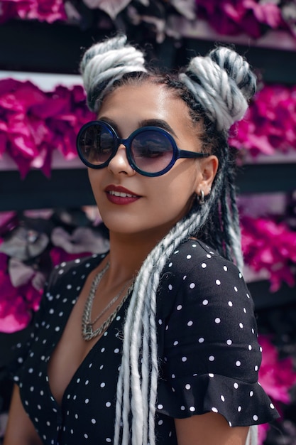 Kunstportret van een mooie vrouw met lange witte dreadlocks in zonnebril