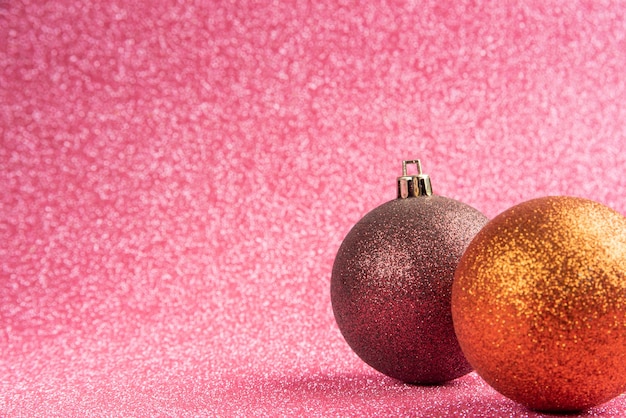 Kunststof en glitter Kerst ornamenten op roze oppervlak met glitter. selectieve aandacht.
