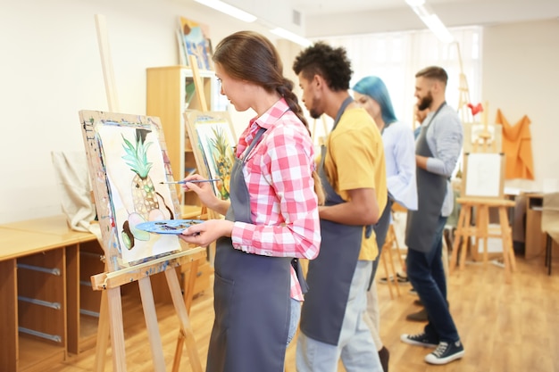 Kunststudenten schilderen in werkplaats