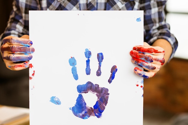 Foto kunsttherapie klas man met a3-poster kleurrijke handafdruk op kunstenaarshanden besmeurd met verf hobby-educatie