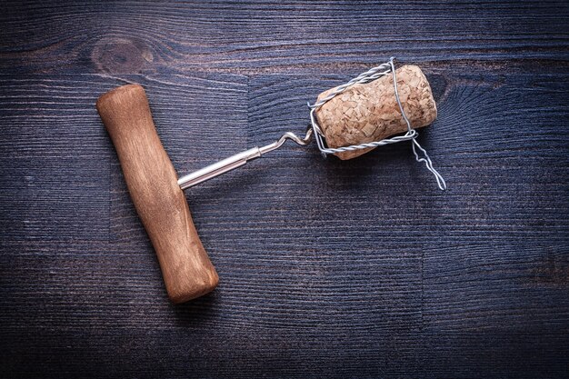 Foto kurkentrekker en champagnekurk met draad op vintage hout