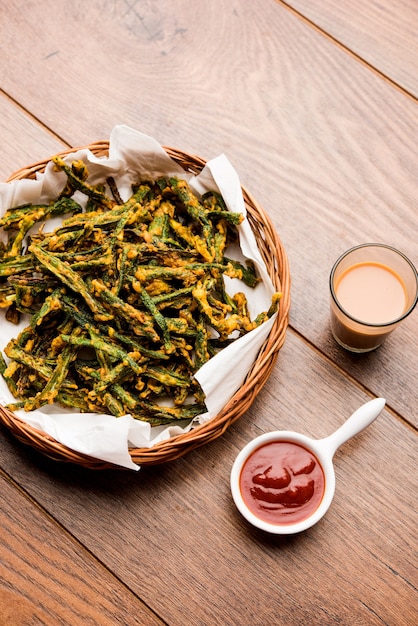 Kurkuri bhindi of crispy ladyfinger of okra fry recept, geserveerd in een kom met ketchup en hete thee. selectieve focus