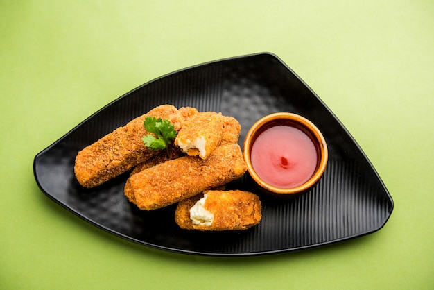 Kurkuri paneer fingers of pakora, pakoda snacks ook wel bekend als Crispy Cottage Cheese Bars, geserveerd met tomatenketchup als voorgerecht. selectieve focus