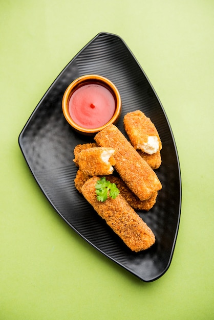 Kurkuri paneer fingers of pakora, pakoda snacks ook wel bekend als Crispy Cottage Cheese Bars, geserveerd met tomatenketchup als voorgerecht. selectieve focus