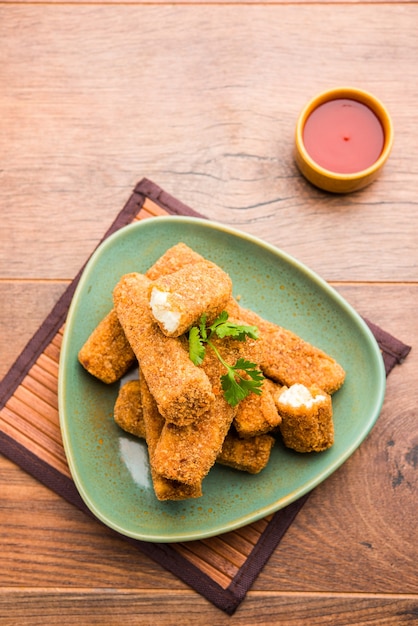 Kurkuri paneer fingers or pakora, pakoda snacks also known as Crispy Cottage Cheese Bars, served with tomato ketchup as a starter. selective focus